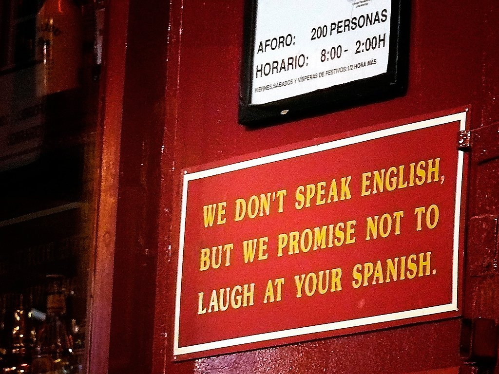 "Não falamos inglês, mas prometemos não rir do seu espanhol" - Placa em algum lugar de língua hispânica | Foto: Arkangel.