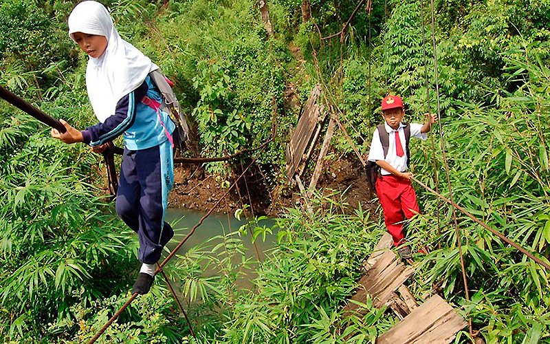 Em área de Sumatra, crianças atravessam nesta precária ponte | Foto: DailyMail.