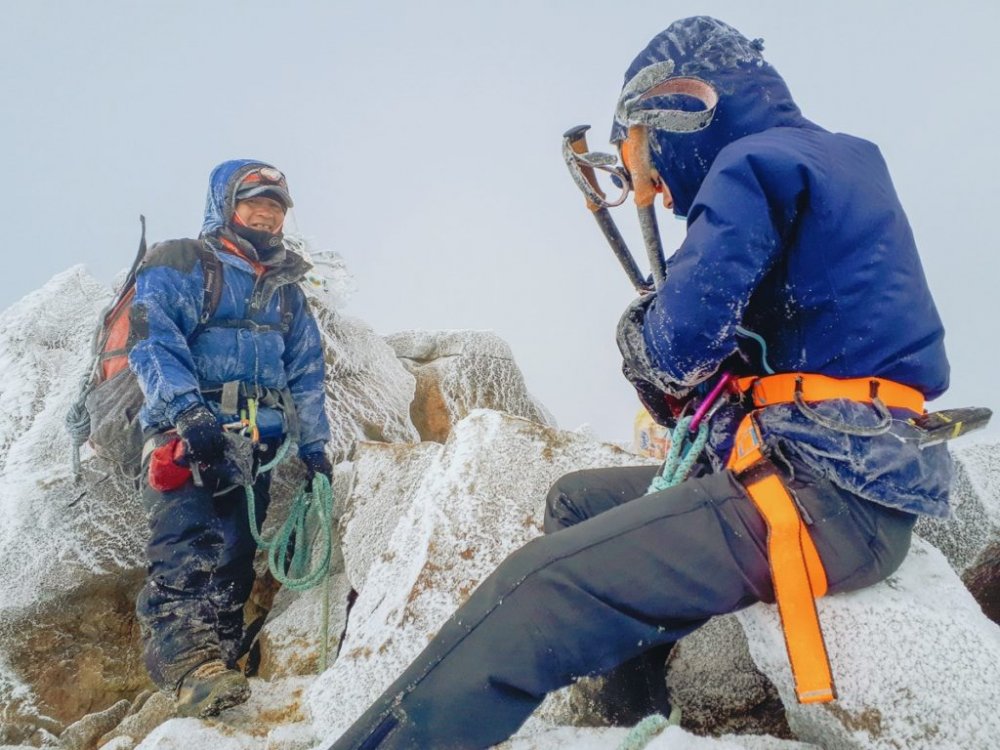 Dá pra ver a cruz no cume do Iliniza Norte atrás do guia.