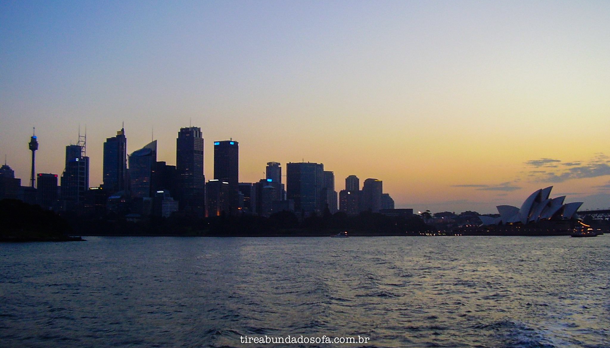 Foto do pôr do sol na Austrália, com o centro da capital ao fundo