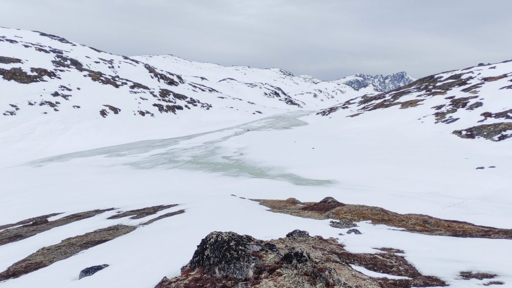 Lago congelado e neve nas montanhas