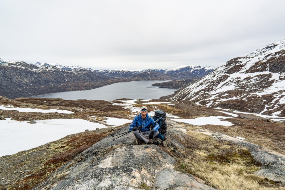 Aventureiro no morro acima do fiorde Kangerluarsuk Tulleq