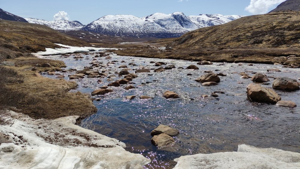 Rio com pedras na trilha nevada
