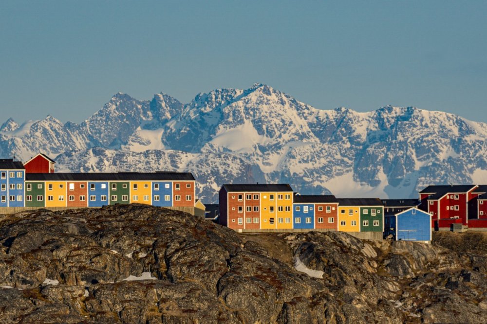 Casas coloridas de Ilulissat com montanhas ao fundo